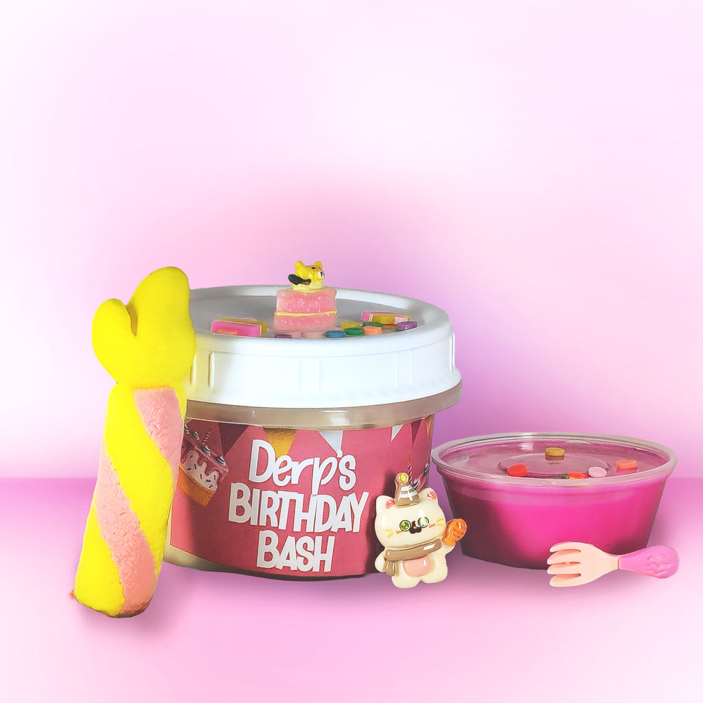 A novelty toy or container labeled 'Derp's Birthday Bash' filled with pale yellow material and decorated with bright pink icing-like drizzle, sprinkles, a yellow mermaid tail, and a small white cat figurine, set against a pink gradient background.